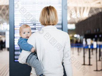 妈妈。旅行孩子持有婴儿婴儿男孩机场终端检查<strong>飞行时</strong>间表等待董事会飞机旅行孩子们概念