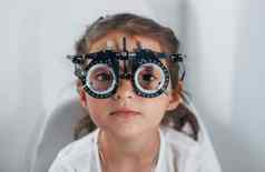 可爱的女孩眼科学诊所特殊的工具眼睛测试