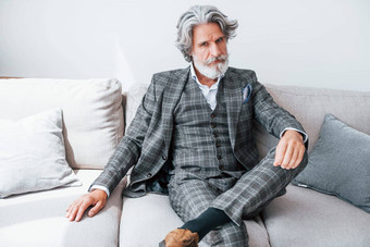 公寓优雅的衣服高级时尚的现代男人。灰色头发胡子在室内