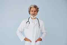 医生白色外套墙高级时尚的现代男人。灰色头发胡子在室内