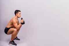 强大的年轻的肌肉发达的集中适合男人。大肌肉持有重壶铃
