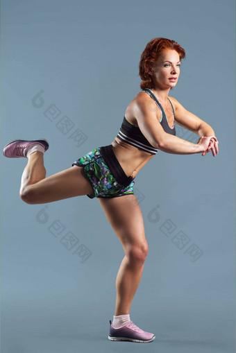 成熟的运动红色头发的人女人运动服装t恤短裤健身练习