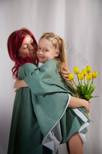 令人惊异的漂亮的妈妈。女儿有趣的花3月母亲的一天红色的头发的妈妈小金发女郎女孩可爱的免费的时间白色背景