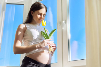 肖像怀孕了女人黄色的郁金香花