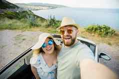 浪漫的夫妇使自拍智能手机相机租赁Cabrio车海洋海海滩享受夏天假期采取图片细胞休息海周末