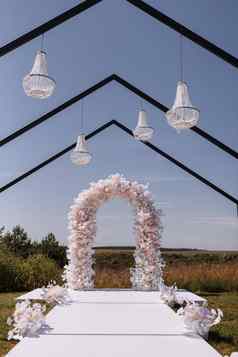 的地方婚礼仪式花园在户外婚礼拱装饰花水晶吊灯婚礼设置