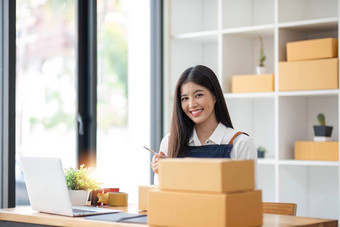 肖像年轻的亚洲女人电子<strong>商务</strong>员工坐着办公室完整的包<strong>背景</strong>写请注意订单计算器锻造业务电子<strong>商务</strong>交付业务