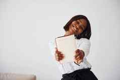 年轻的非洲美国女人正式的衣服站记事本空纸手在室内