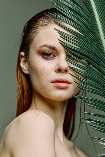 关闭美肖像美丽的女人站持有热带棕榈叶手把脸相机垂直照片修版问题皮肤