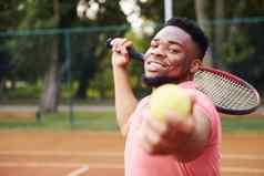 非洲美国男人。粉红色的衬衫戏剧网球法院在户外
