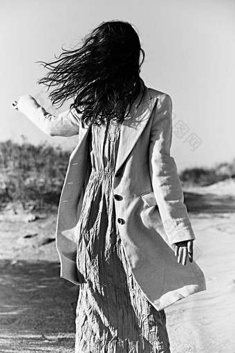 单色<strong>照片旋转</strong>女人海岸浅色的夹克脸覆盖头发