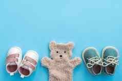 婴儿鞋子熊玩具蓝色的纸背景复制空间新生儿女孩男孩概念前