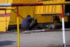 工人修复船焊接机工人的后视图气体气缸修复组件船修复特写镜头照片黄色的红色的背景工业工作照片