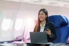 美丽的亚洲女商人工作移动PC飞机工作旅行业务概念