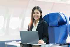 美丽的亚洲女商人工作移动PC飞机工作旅行业务概念