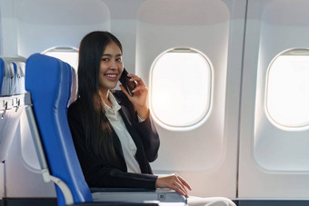 美丽的亚洲业务女人聊天客户<strong>端移动</strong>电话飞行工作旅行业务概念