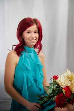 美丽的女人红色的头发黄色的衣服光背景持有大花束玫瑰花国际先进女人的一天3月