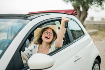 年轻的快乐女人显示关键车租赁买车概念