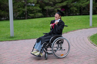 快乐高加索人女人轮椅持有文凭在户外