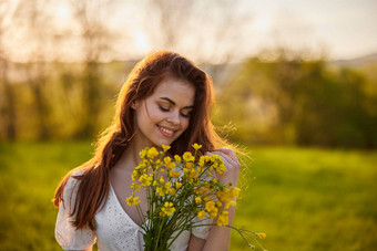 肖像快乐女人花束黄色的花照亮回来设置太阳