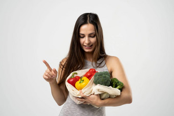 微笑浅黑肤色的女人女孩持有网购物袋<strong>蔬菜</strong>绿色塑料袋浪费塑料<strong>免</strong>费的生态友好的概念可持续发展的生活方式