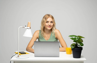 年轻的有吸引力的业务女人坐着表格工作移动PC会说话的客户端