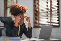 年轻的非洲美国女人非洲式发型发型生气强调坐着桌子上移动PC思考相机感觉累了无聊抑郁症问题