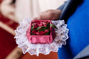 新郎持有黄金婚礼环装饰盒子绿色植物红色的布新娘早....婚礼一天高质量照片