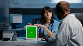 医生护士持有平板电脑电脑指出绿色屏幕显示