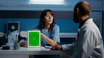 医疗助理持有设备指出绿色屏幕显示讨论病人专业<strong>知识</strong>