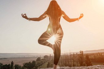 健身女人中间岁的女人长头发健身教练紧身裤上衣伸展运动普拉提岩石森林女健身瑜伽例程概念