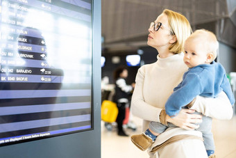 妈妈。旅行孩子持有婴儿婴儿男孩机场终端检查<strong>飞行时</strong>间表等待董事会飞机旅行孩子们概念