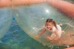 快乐的女孩有趣的内部浮动水走球