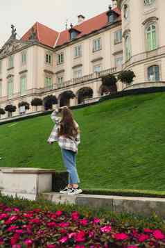 女女人旅行者观光假期假期概念美丽的紫罗兰色的花城堡花园背景相邻皇家城堡华沙一边维斯瓦河旅游吸引力