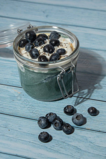 玻璃Jar自然有机自制的酸奶蓝莓螺旋藻小球藻超级食物超级粉蓝色的藻类海杂草提高免疫力成分概念健康的吃早餐希腊酸奶发酵
