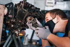 专业修理工黑色的保护面具作品破碎的汽车引擎