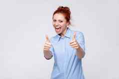 快乐的快乐的很高兴女人穿蓝色的衬衫显示拇指享受服务推荐