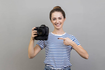 女人指出专业数字数码单反相机相机露出牙齿的微笑享受工作