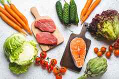 食物生产品蔬菜牛肉肉牛排鱼大马哈鱼角木切割董事会白色乡村表格前视图健康的食物成分背景饮食平衡营养