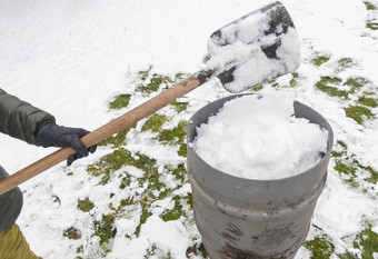 中年女人收集雪桶铲自然资源