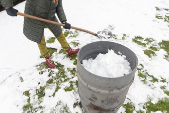 中年女人收集雪桶铲自然资源