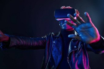 虚拟现实经验未来主义的霓虹灯照<strong>明年</strong>轻的非洲美国男人。工作室