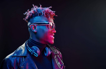时尚的眼镜无线耳机未来主义的霓虹灯照<strong>明年</strong>轻的非洲美国男人。工作室