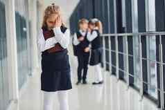 女孩欺负概念骚扰学校孩子们统一的走廊
