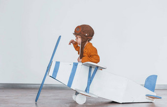 男孩<strong>复古</strong>的飞行员统一的有趣的玩具飞机在<strong>室内</strong>