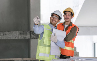 年轻的男人。建设团队工程师背心他工作移动PC站建设网站房子建筑项目工程师会说话的的同事们工作