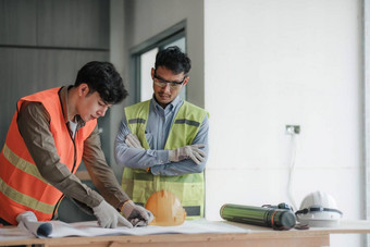 年轻的男人。建设团队工程师背心他工作移动PC站建设网站房子建筑项目工程师会说话的的同事们工作