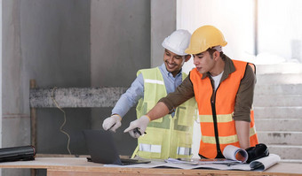 年轻的男人。建设团队工程师背心他工作移动PC站建设网站房子建筑项目工程师会说话的的同事们工作