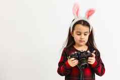 快乐复活节概念可爱的女孩粉红色的兔子耳朵兔子耳朵持有相机