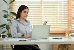 美丽的亚洲女经理移动PC聊天客户端在线给互联网咨询客户
